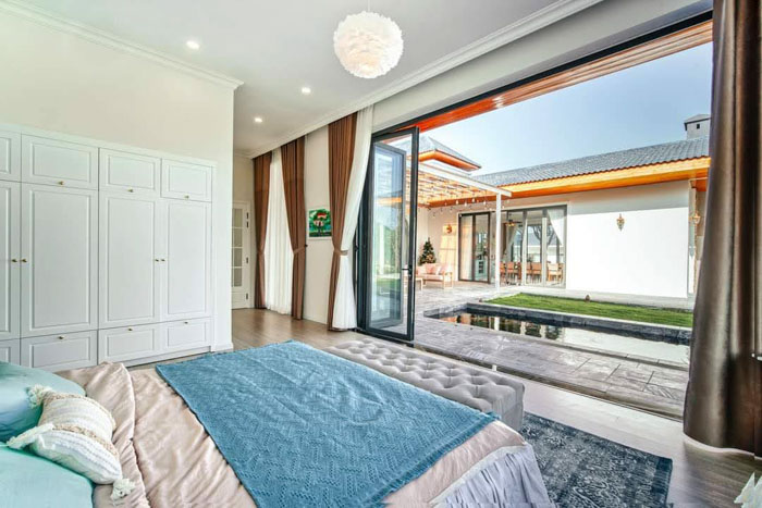 Giường trong thiết kế biệt thự nghỉ dưỡng gần bể bơi bên ngoài